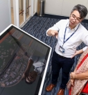 Dr. Maggie Mai from Hong Kong Science and Technology Park listened to the introduction of touch table by Wisdom Chan, Chain Technology Officer from Chain Technology Development.